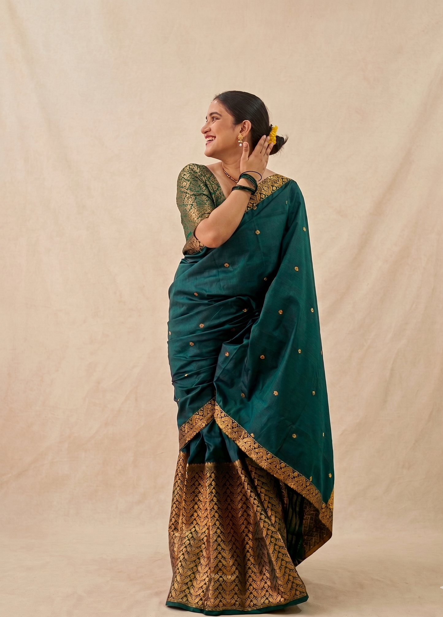 Woman wearing a fully stitched Assamese Mekhela Chador, showing the traditional three pleats and Chador drape over the shoulder.