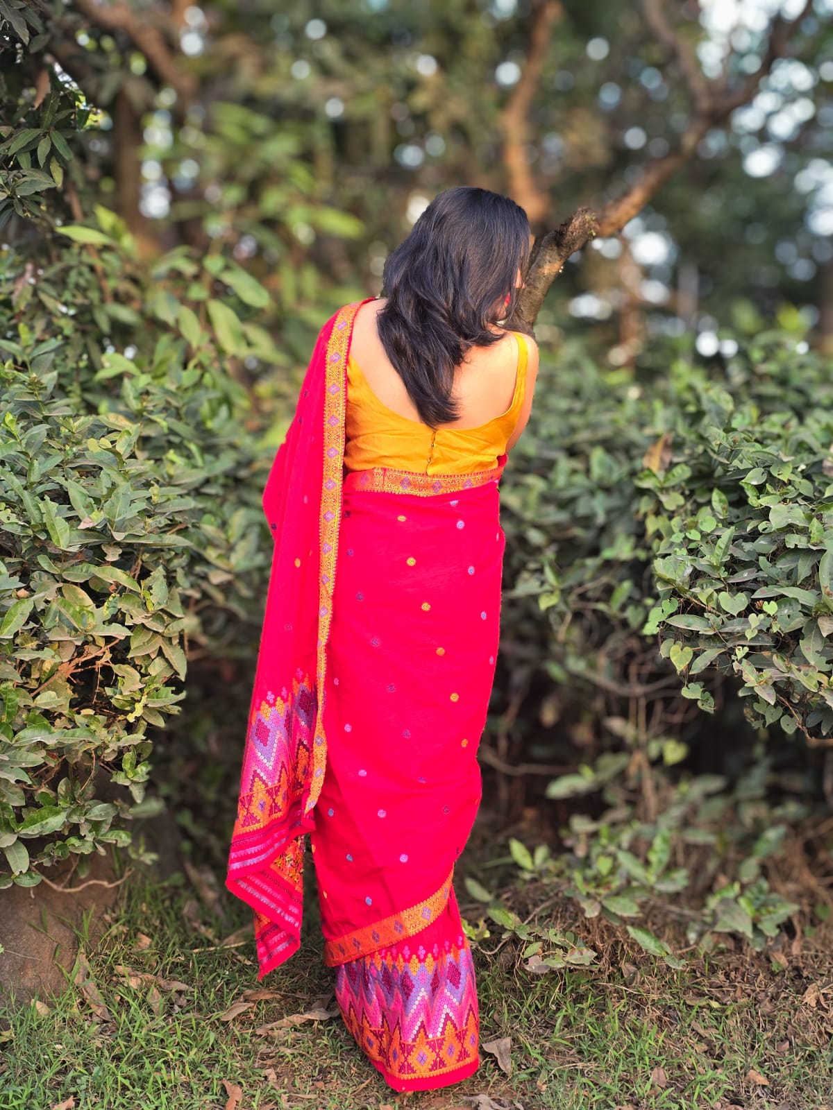 Handwoven multi-color border and blouse piece of a red Mishing Mekhela Chador set.