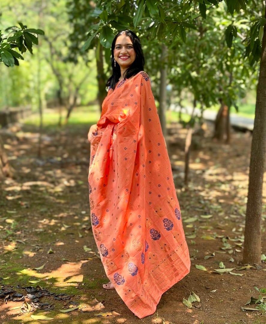 Handwoven coral orange Mekhela Chador from Assam with traditional woven motifs