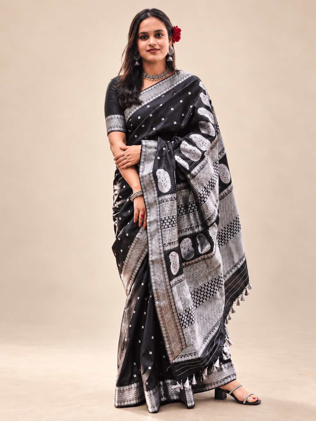 Full drape of a black saree featuring silver paisley motifs, small woven details and a statement patterned pallu.