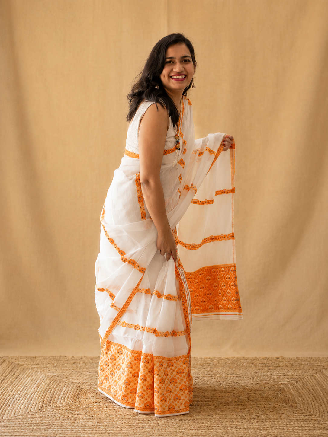 Chandralekha side view of white cotton mekhela chador with orange motif