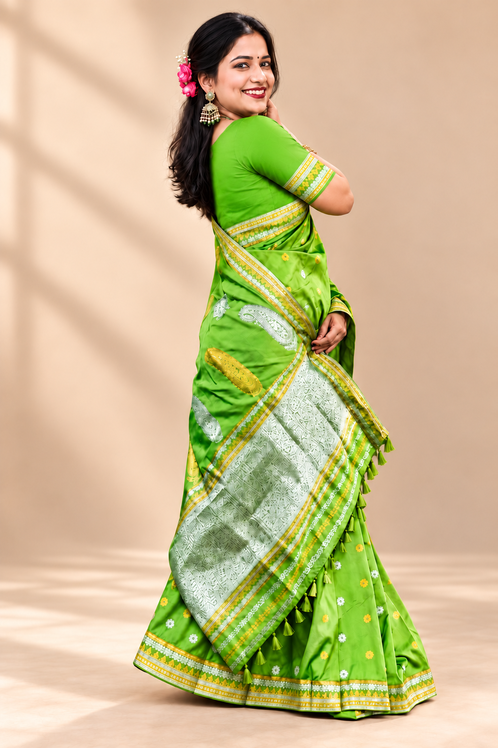 Green saree with silver woven border, yellow accents and small floral motifs styled for festive and cultural occasions.