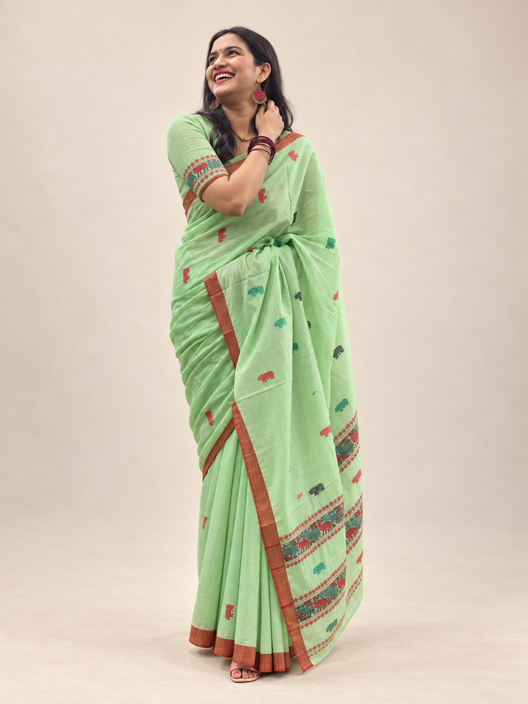 Mint green Assam saree with Kaziranga-inspired one-horned rhino motifs and contrast border by Apaapi.