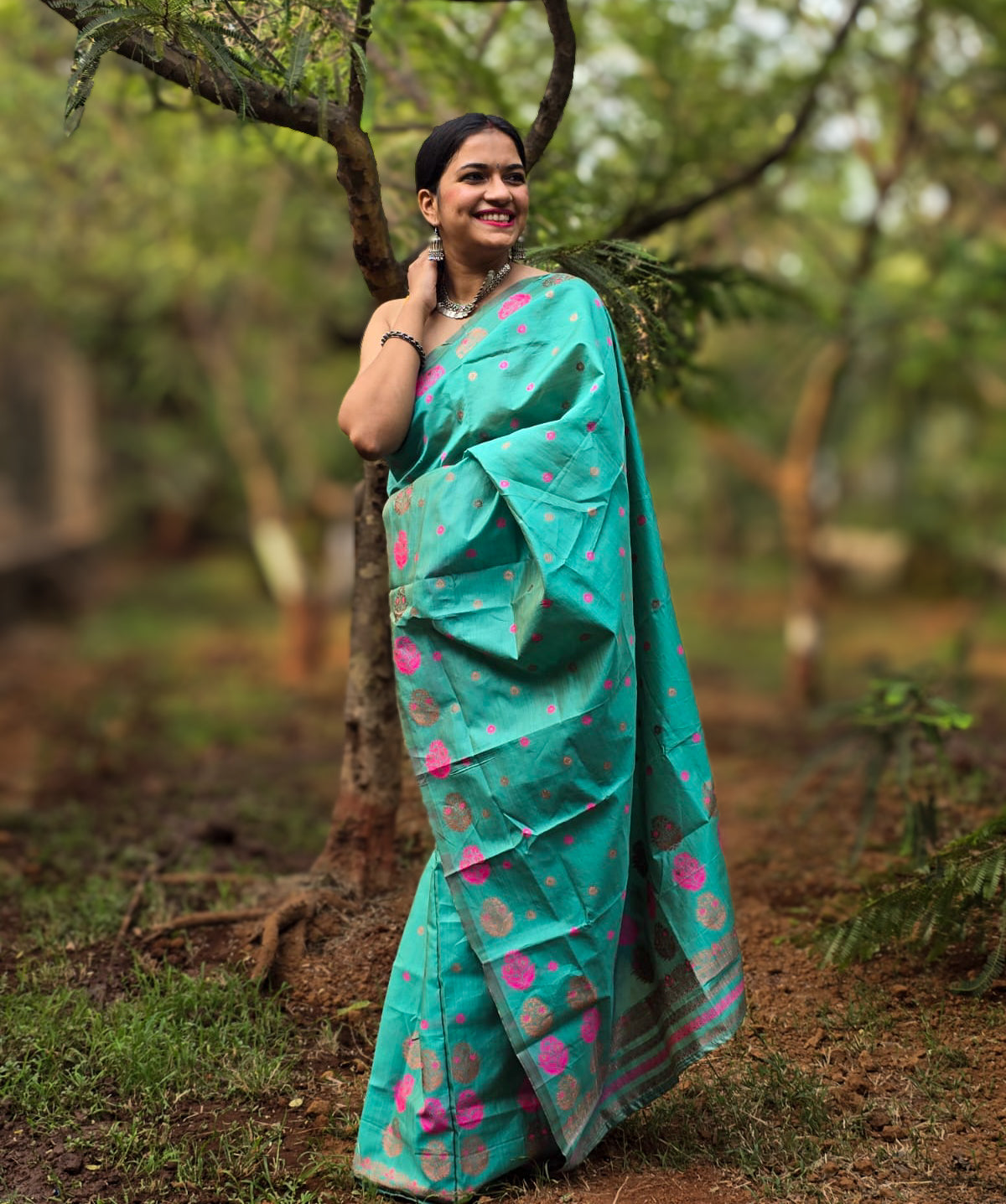 Handwoven teal Mekhela Chador from Assam with pink woven motifs